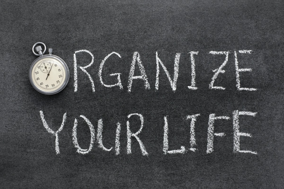organize your life phrase handwritten on chalkboard with vintage precise stopwatch used instead of O