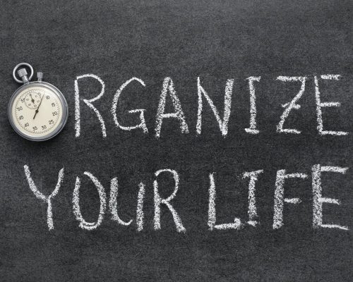 organize your life phrase handwritten on chalkboard with vintage precise stopwatch used instead of O